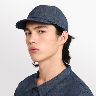 side view of ciele athletics CRWCap short brim unisex running hat with shorter brim from the Lifestyle Edition collection, in denim indigo color, on a model